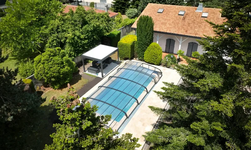 Vue aérienne par drone d’une piscine rénovée avec abri télescopique, chantier terminé près de Bordeaux