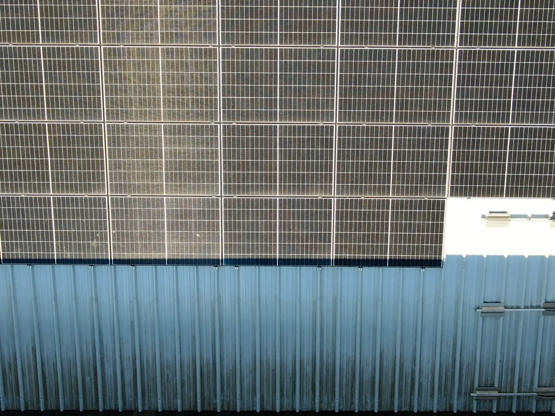 Photo visible d’une ombre portée par un shed sur des panneaux photovoltaïques