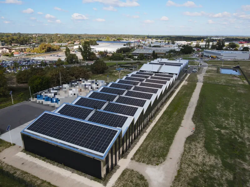 Vue aérienne par drone de la toiture en sheds d’une centrale photovoltaïque industrielle en Gironde