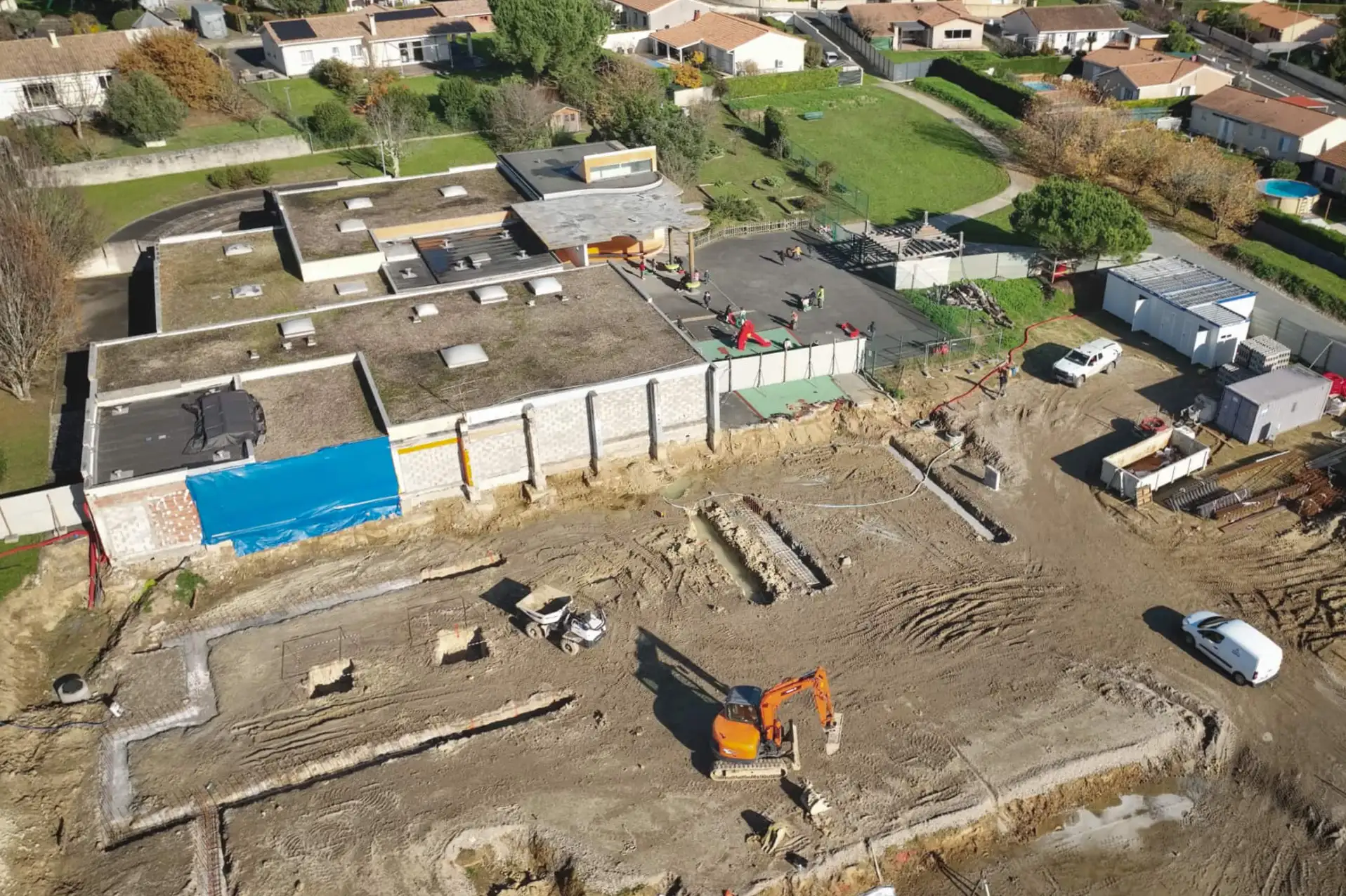 Vue aérienne par drone d’un chantier d’extension d’école en cours à Carbon-Blanc, terrassement et engins de chantier