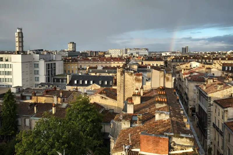 Drone en vol au-dessus d’un environnement urbain dense à Bordeaux, caméra orientée vers l’axe de la rue